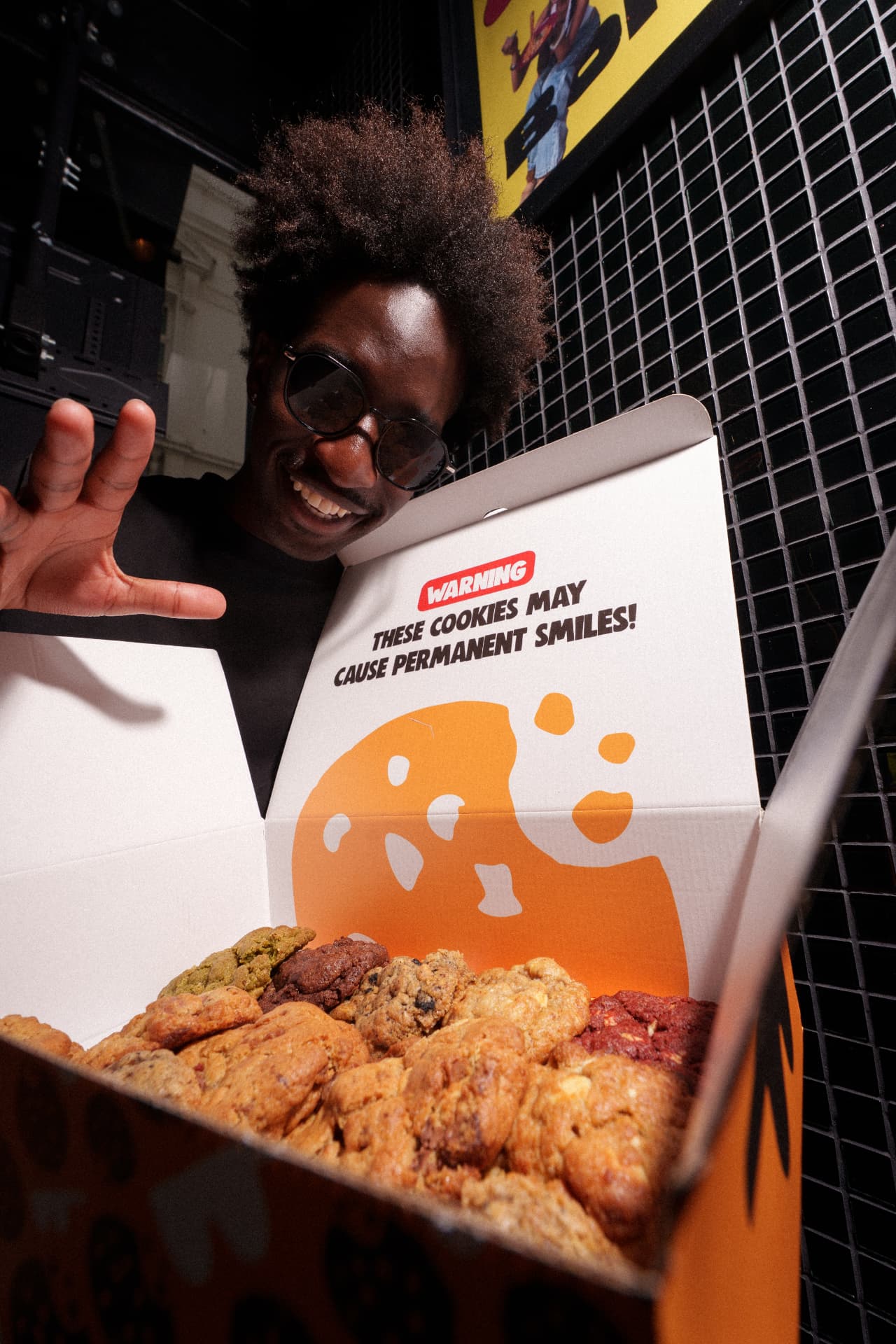 Man reaching over an open box full of Daily Cookies