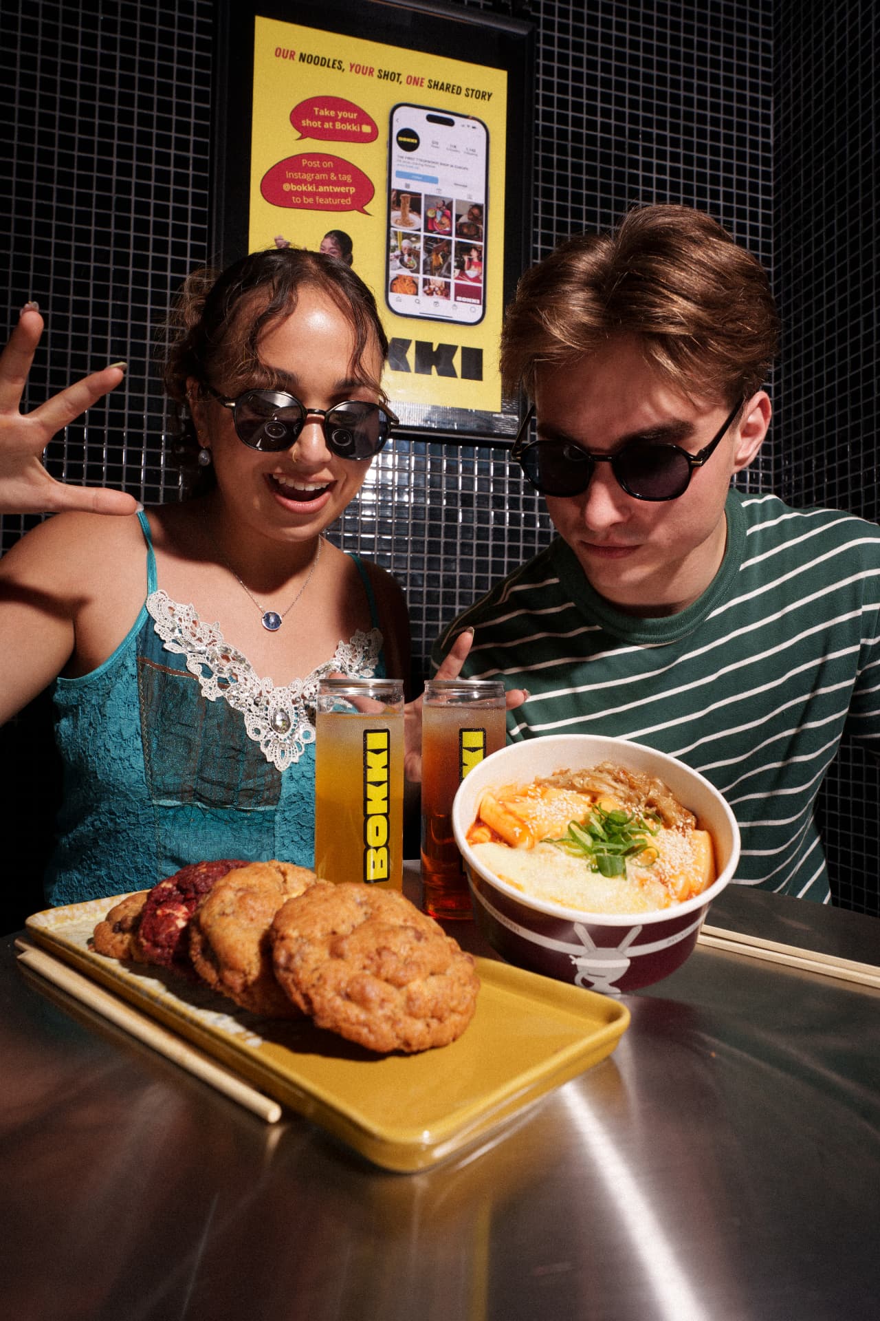 Two friends with sunglasses sharing Daily Cookies with noodles at Bokki